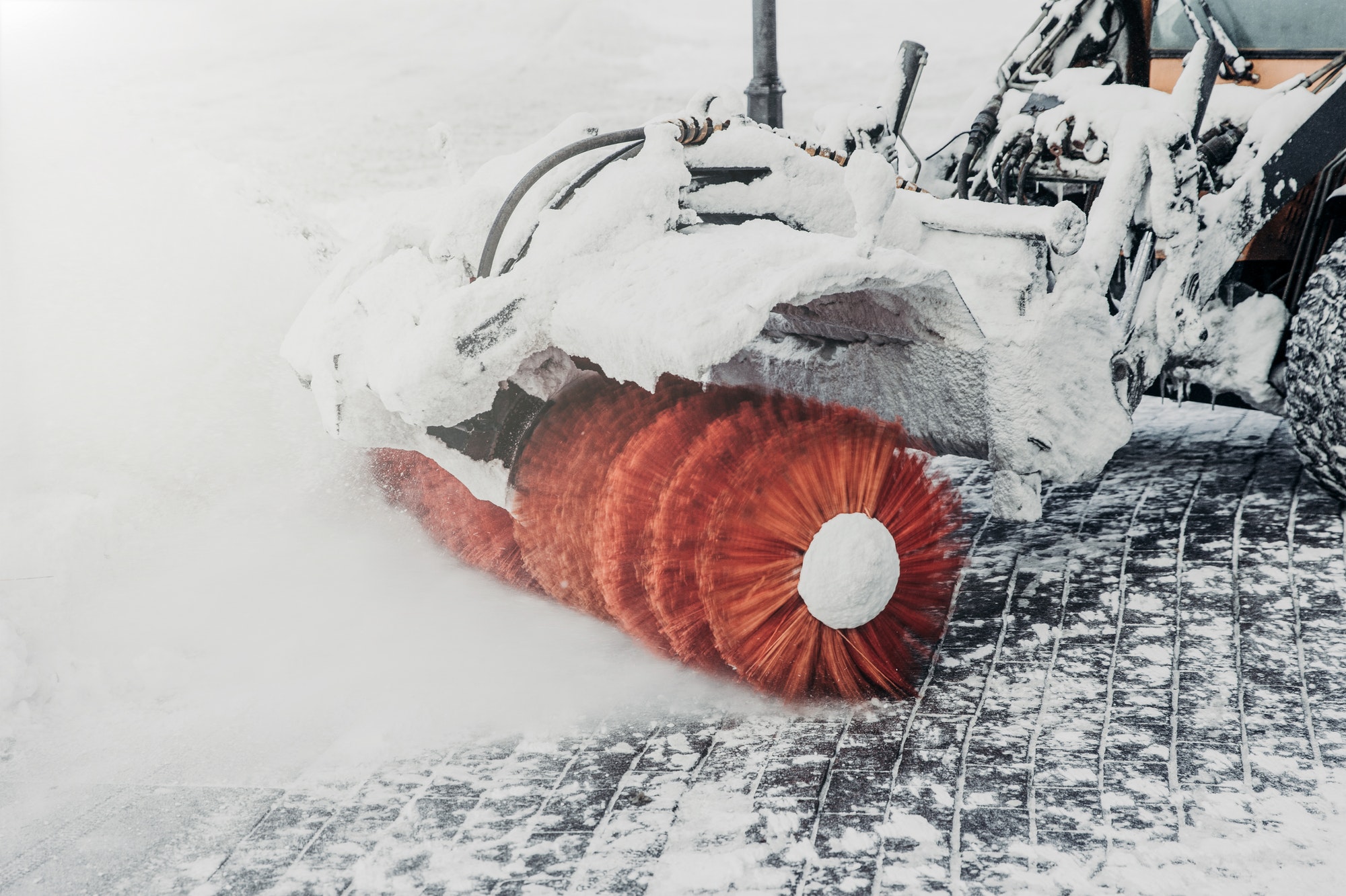 Tractor cleans road from snow after blizzard or heavy snowstorm. Cleaning or plowing snow